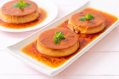 Ev yapımı karamel kremalı puding ahşap arka plan üzerinde