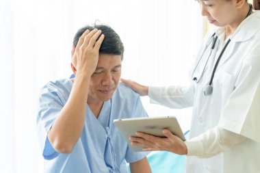 Asya kıdemli hasta hastane yatak kadın doktor - seçici odak noktası ile tartışırken.