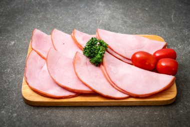 Ahşap tahta üzerinde dilimlenmiş jambon füme