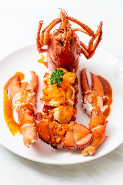 Soslu ıstakoz kuyruklu biftek ve beyaz arka planda karides yumurtaları.