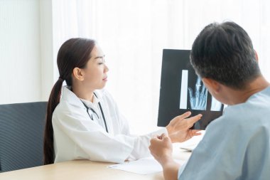 Asyalı kadın doktor ve hasta masada - seçici otururken bir şey tartışırken noktaya odaklama