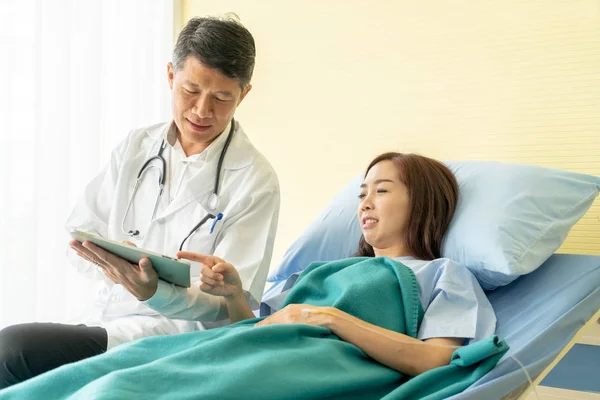 Asijský Senior Lékař Sedí Nemocničním Lůžku Diskutuje Pacientkou Selektivní Zaostření — Stock fotografie