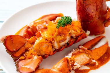 Soslu ıstakoz kuyruklu biftek ve beyaz arka planda karides yumurtaları.