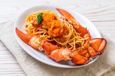 Beyaz tabakta karides yumurtalı ıstakoz spagettisi.