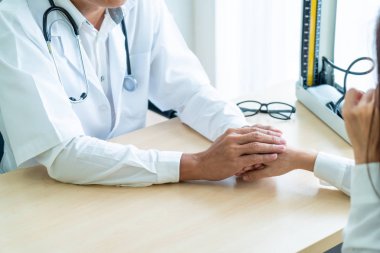 Kıdemli doktor kadın hastasını güven verici el