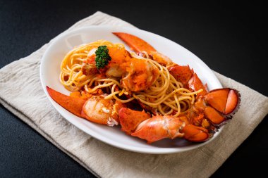 Beyaz tabakta karides yumurtalı ıstakoz spagettisi.