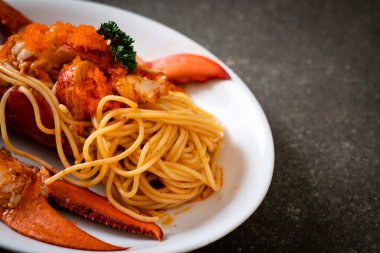 Beyaz tabakta karides yumurtalı ıstakoz spagettisi.