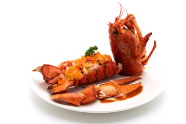 Soslu ıstakoz kuyruklu biftek ve beyaz arka planda karides yumurtaları.