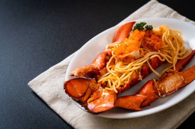 Beyaz tabakta karides yumurtalı ıstakoz spagettisi.