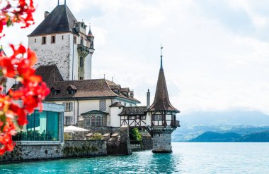 Thun Gölü arka planda İsviçre ile Oberhofen kalesinde güzel mimari