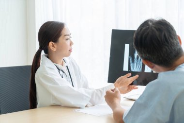 Asyalı kadın doktor ve hasta masada - seçici otururken bir şey tartışırken noktaya odaklama