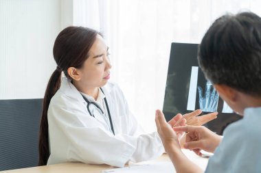 Asyalı kadın doktor ve hasta masada - seçici otururken bir şey tartışırken noktaya odaklama