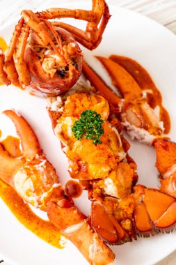 Soslu ıstakoz kuyruklu biftek ve beyaz arka planda karides yumurtaları.