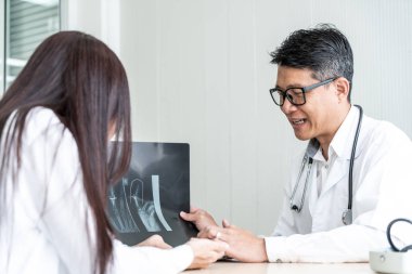 Asyalı doktor ve hasta röntgen film Office ile görüşüyorlar