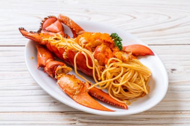 Beyaz tabakta karides yumurtalı ıstakoz spagettisi.