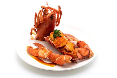 Soslu ıstakoz kuyruklu biftek ve beyaz arka planda karides yumurtaları.