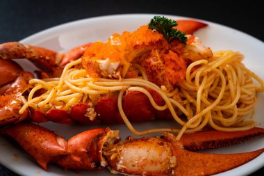 Beyaz tabakta karides yumurtalı ıstakoz spagettisi.