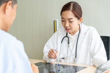 Asyalı kadın doktor ve hasta masada - seçici otururken bir şey tartışırken noktaya odaklama