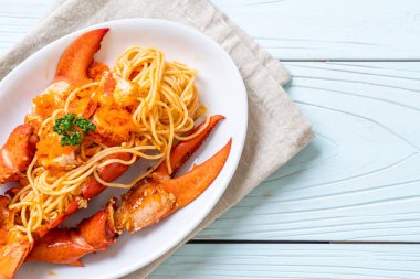 Beyaz tabakta karides yumurtalı ıstakoz spagettisi.