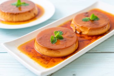 Ev yapımı karamel kremalı puding ahşap arka plan üzerinde