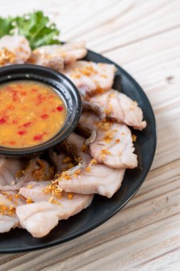 Soslu ve sebzeli haşlanmış balık sosu.