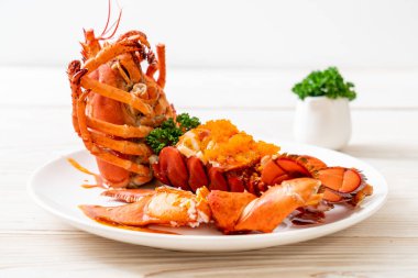 Soslu ıstakoz kuyruklu biftek ve beyaz arka planda karides yumurtaları.