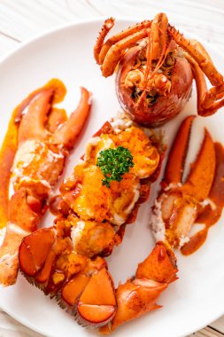 Soslu ıstakoz kuyruklu biftek ve beyaz arka planda karides yumurtaları.