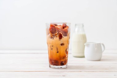 Tay çay buz küpü ile ahşap arka plan üzerinde süt