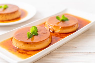 Ev yapımı karamel kremalı puding ahşap arka plan üzerinde