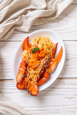 Beyaz tabakta karides yumurtalı ıstakoz spagettisi.