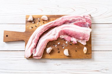 madde ile ahşap tahta üzerinde taze çiğ çizgili domuz eti
