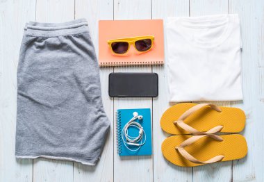 Gezgin, yaz tatili ahşap arka plan üzerinde erkek casual kıyafetler