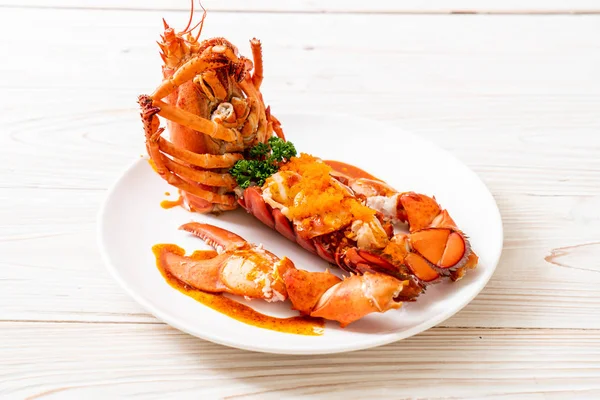 Soslu ıstakoz kuyruklu biftek ve beyaz arka planda karides yumurtaları.