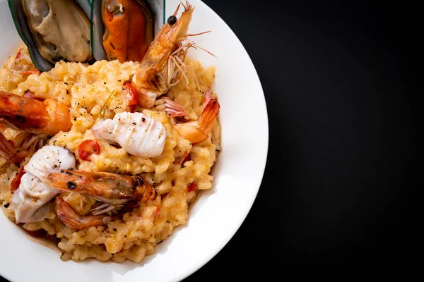 risotto with seafoods (shrimps, mussels, octopus, clams) and tomatoes - Italian food style