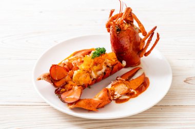 Soslu ıstakoz kuyruklu biftek ve beyaz arka planda karides yumurtaları.