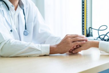 Kıdemli doktor kadın hastasını güven verici el