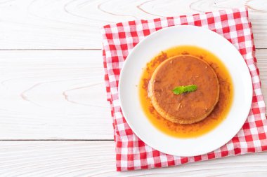 Ev yapımı karamel kremalı puding ahşap arka plan üzerinde