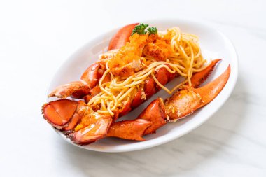 Beyaz tabakta karides yumurtalı ıstakoz spagettisi.