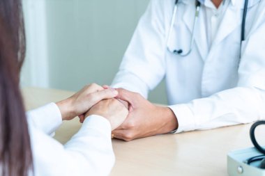 Kıdemli doktor kadın hastasını güven verici el