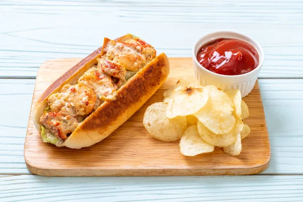 homemade lobster roll with potato chips on wooden board