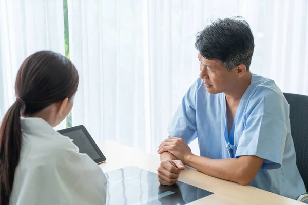 Asian Senior Patient Having Consultation With Doctor in Office  - selective focus point