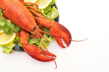 Beyaz arka planda taze haşlanmış sebze ve limonlu ıstakoz.