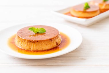 Ev yapımı karamel kremalı puding ahşap arka plan üzerinde