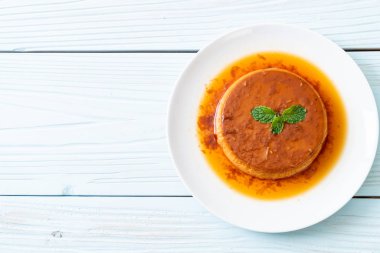 Ev yapımı karamel kremalı puding ahşap arka plan üzerinde