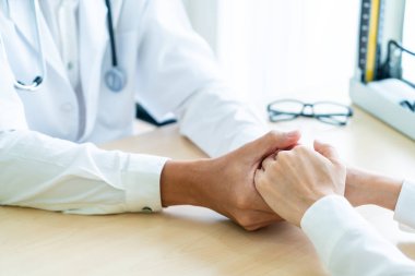 Kıdemli doktor kadın hastasını güven verici el