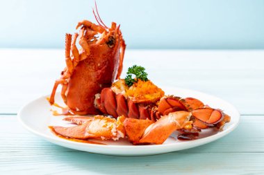 Soslu ıstakoz kuyruklu biftek ve beyaz arka planda karides yumurtaları.