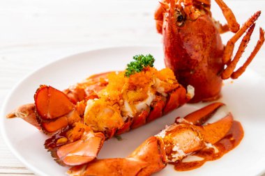 Soslu ıstakoz kuyruklu biftek ve beyaz arka planda karides yumurtaları.