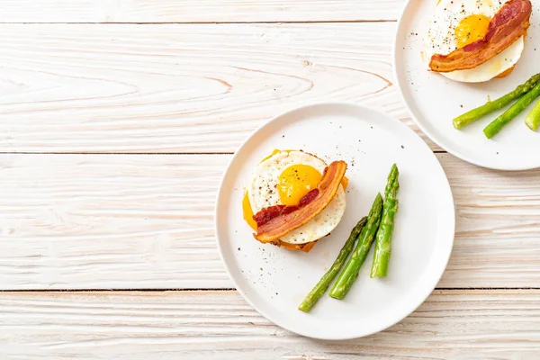 fried egg with bacon and cheese on pancake for breakfast