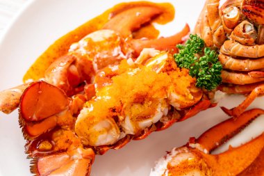 Soslu ıstakoz kuyruklu biftek ve beyaz arka planda karides yumurtaları.