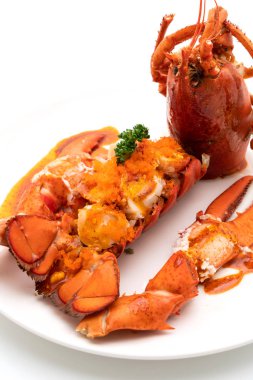 Soslu ıstakoz kuyruklu biftek ve beyaz arka planda karides yumurtaları.